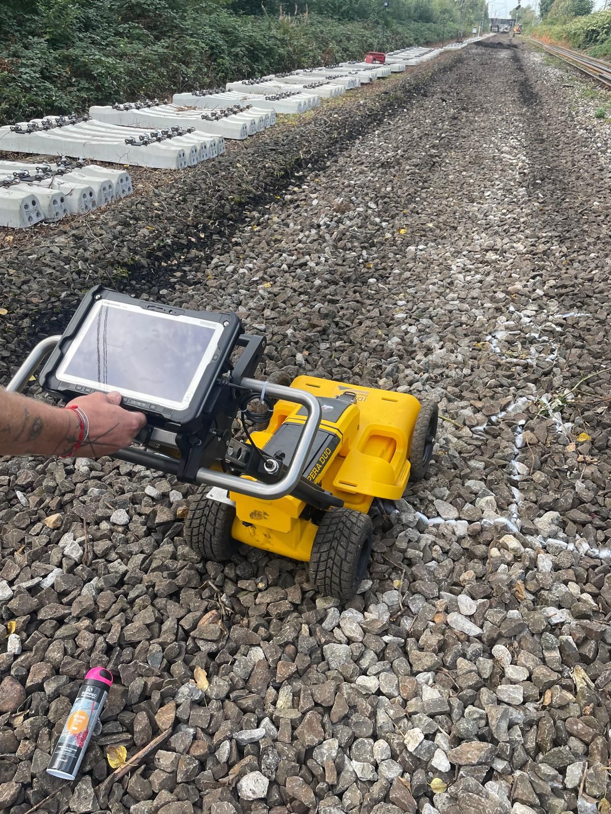Georadar IDS Opera Duo mit Display auf Gleisschotter neben abgelegten Betonschwellen.
